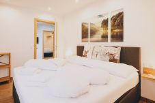 Bedroom in the holiday apartment by we rent apartments, featuring a cozy double bed with a nature poster on the wall.