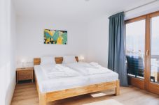 Bedroom in the holiday apartment Haus Altenberger Apartments by we rent. Double bed with access to the balcony and a view.